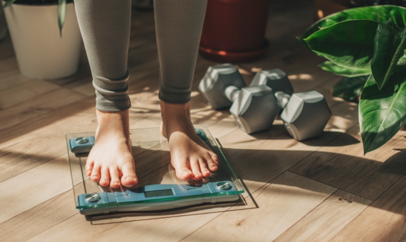 Person standing on weight scales: for many, achieving remission often requires significant weight loss