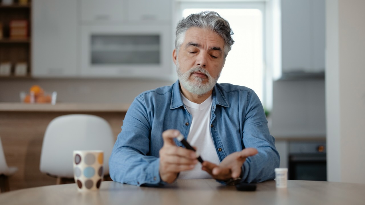 Man checks his blood glucose levels: keeping blood glucose levels within the right range is important for type 1 diabetes management