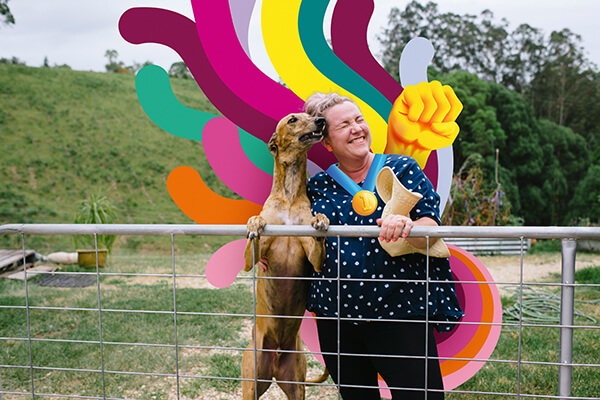 Woman and dog standing at fence
