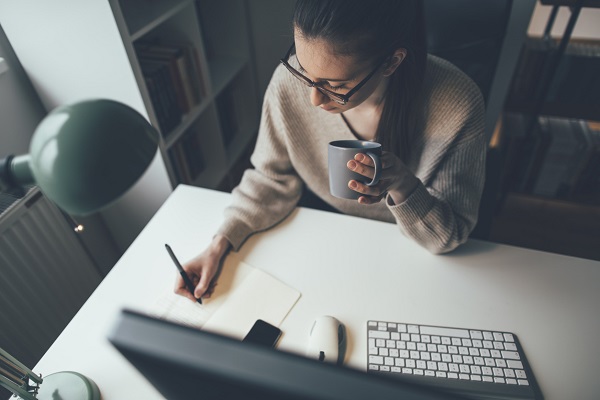 Young businesswoman easing working long hours with coffee at her home office