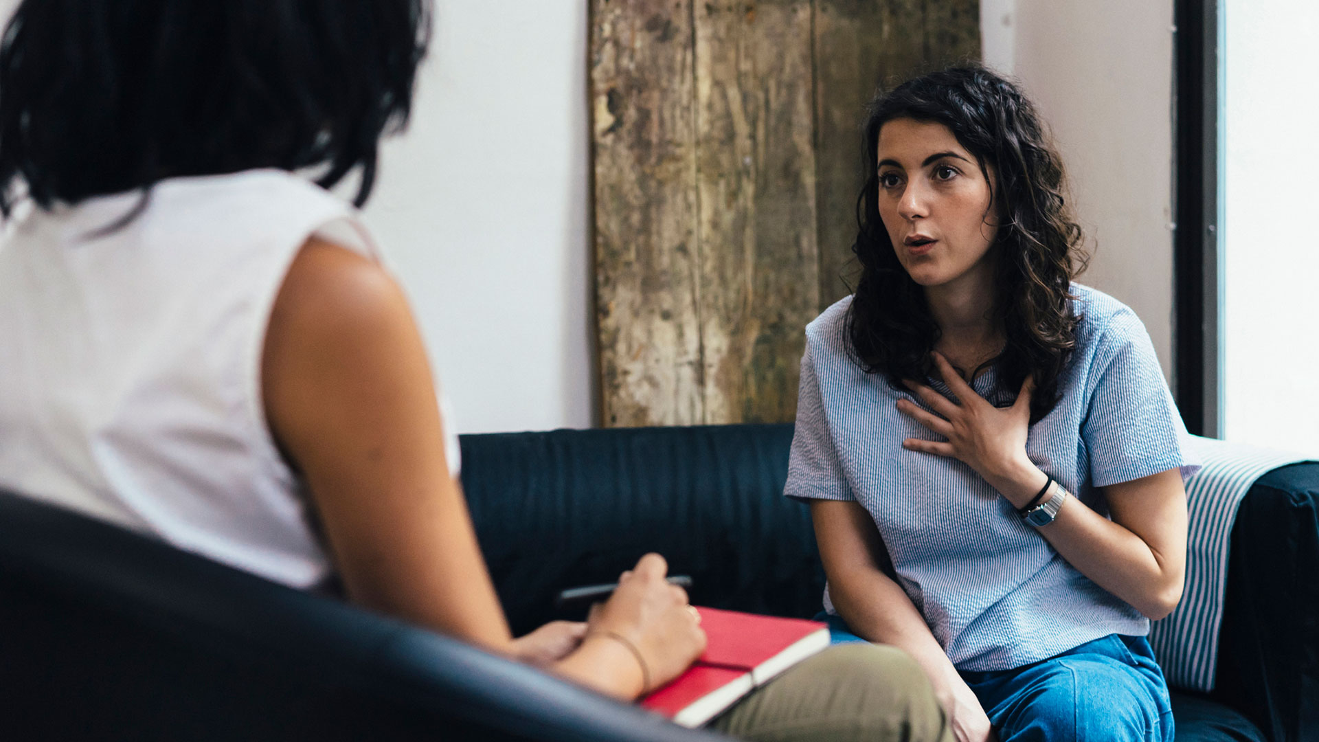 814596226 Young woman talking to a mental health professional on a couch