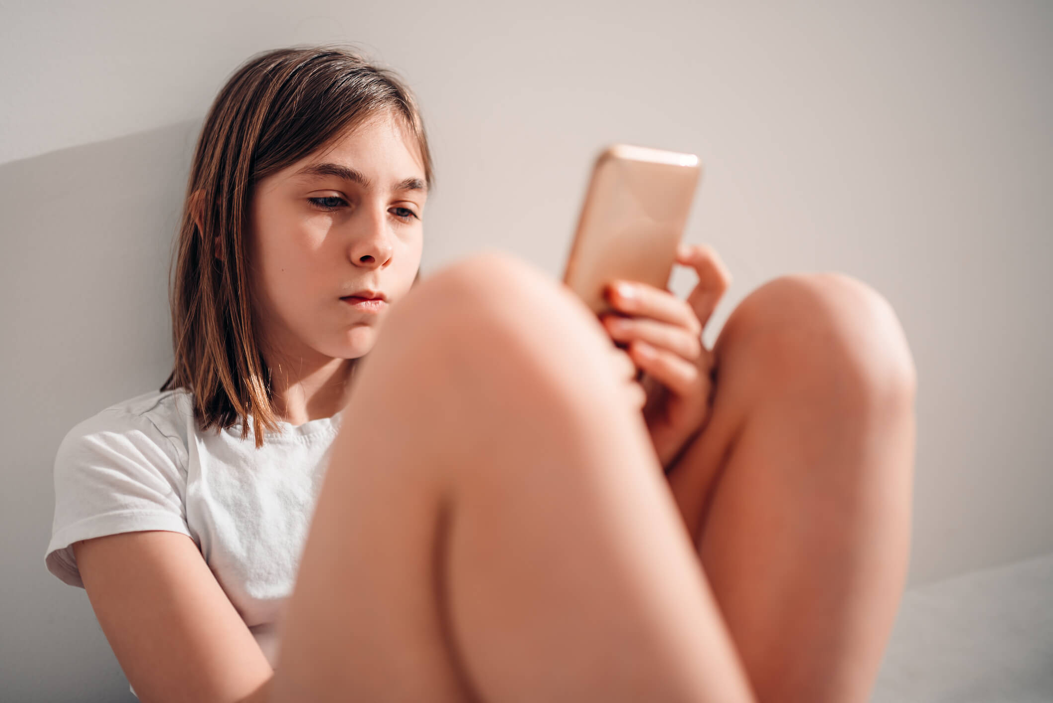 Young girl using phone A young girl looks at her smartphone.