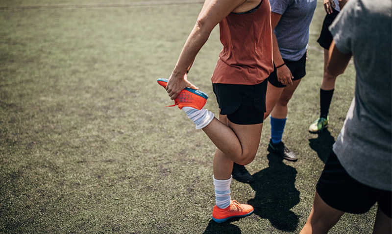 woman stretching before playing soccer