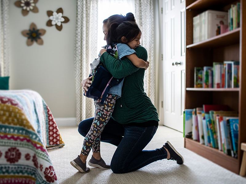 Mum hugging daughter before school