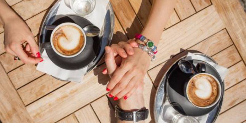 holding hands over a coffee holding hands over a coffee