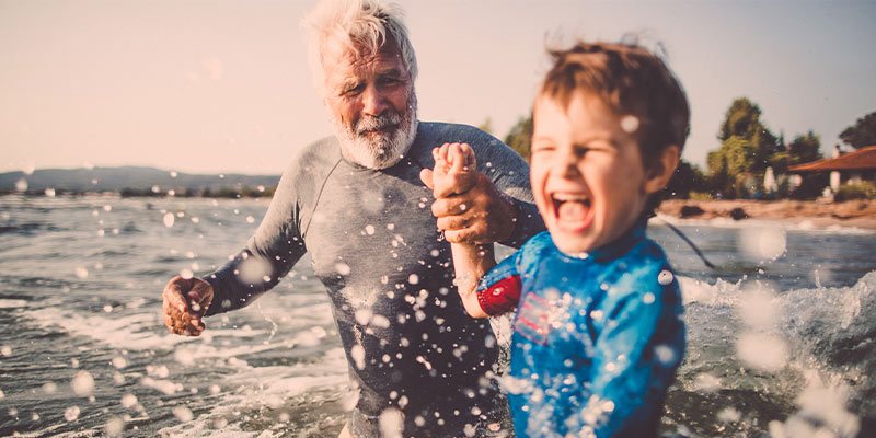 A grandfather and grandson going for a surf A grandfather and grandson going for a surf