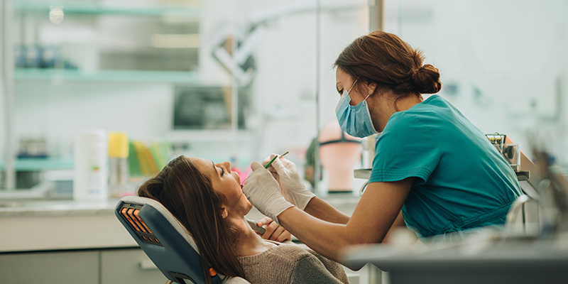 a dentist delivering a dental procedure a dentist delivering a dental procedure