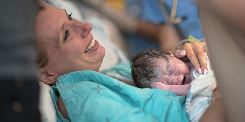 A new mother embracing her newborn A new mother embracing her newborn