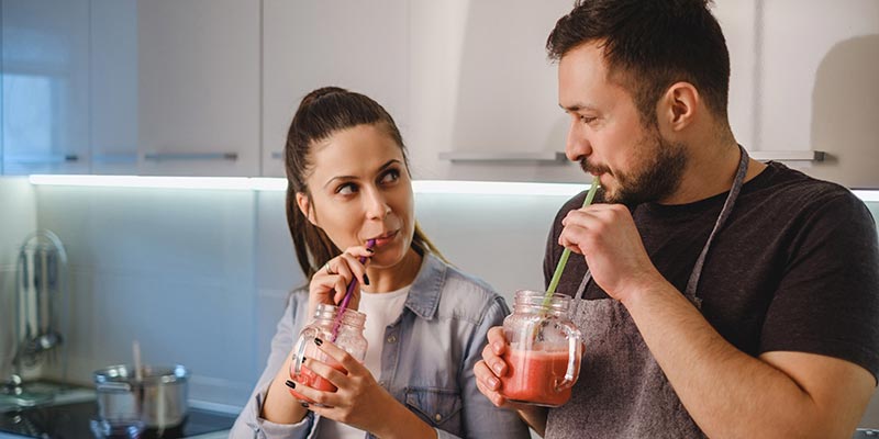 A couple drinking healthy smoothies A couple drinking healthy smoothies