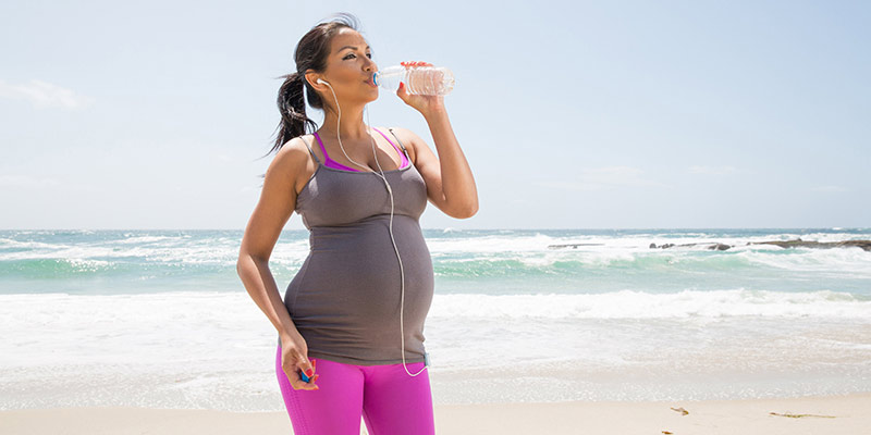 A woman drinking water after exercising A woman drinking water after exercising