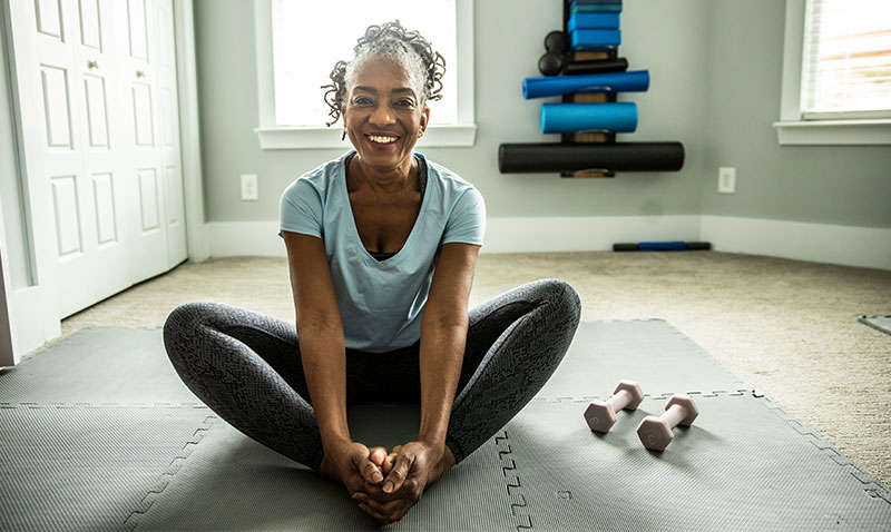 woman performing stretches on the floor at home woman performing stretches on the floor at home